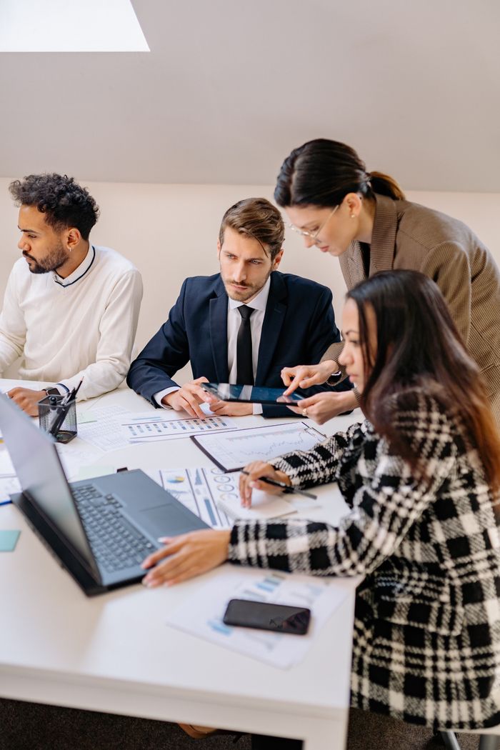 Services Professionals engaged in a meeting discussing plans in a modern office setting.