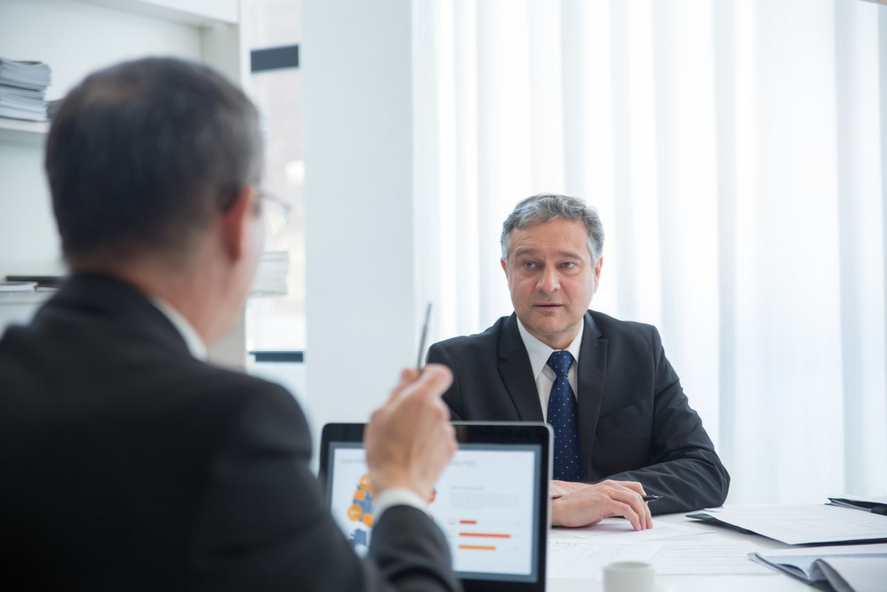 Services Business professionals in a focused discussion during an office meeting.